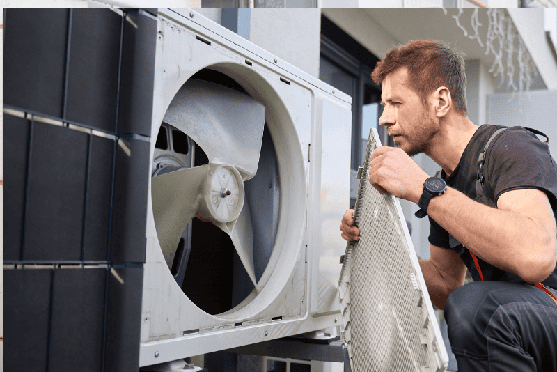 HVAC technician inspecting outdoor AC unit for compressor issues in Charlotte, NC