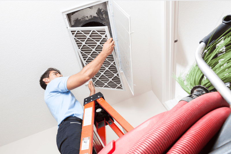 HVAC technician cleaning home air ducts in Charlotte